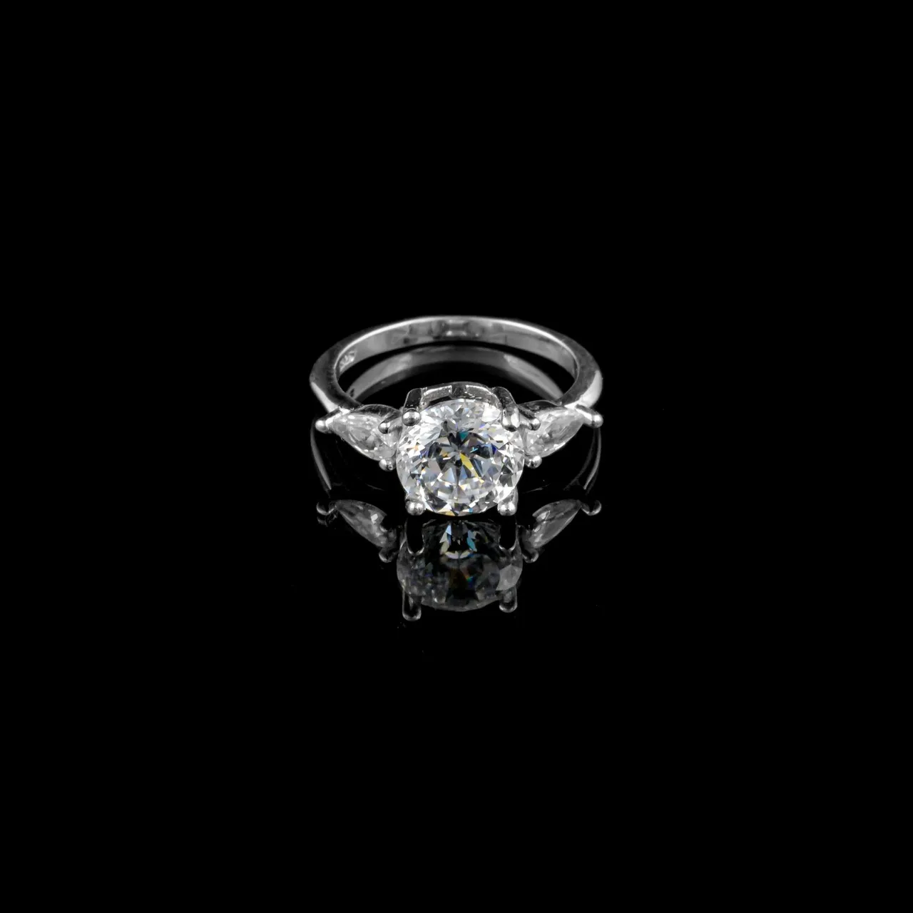 A solitaire ring illuminated against a dark backdrop