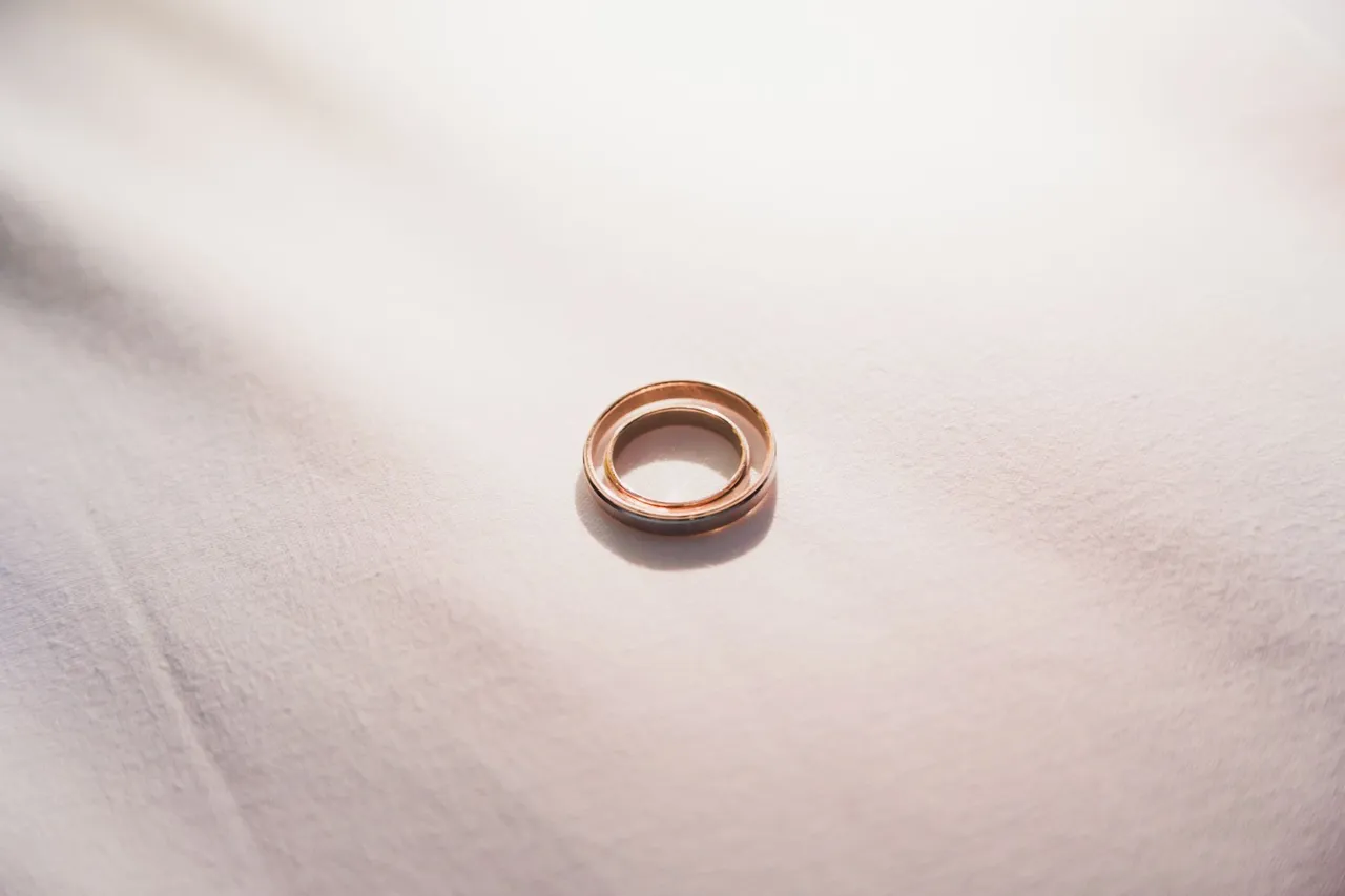 Two wedding bands resting on soft ivory fabric